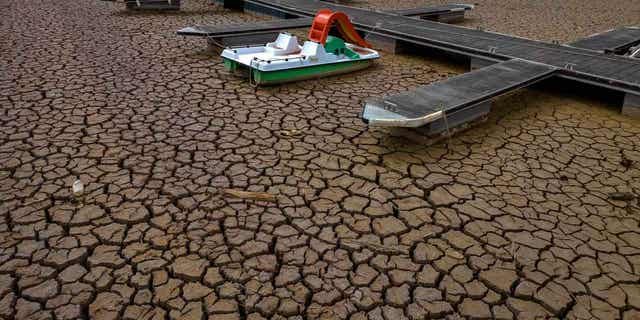 Pedal boat tied to dock on dried up reservoir