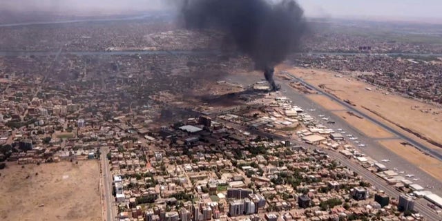 This image grab taken from AFPTV video footage on April 20, 2023, shows an aerial view of black smoke rising above the Khartoum International Airport