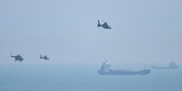 Chinese military helicopters fly past Pingtan island, one of mainland China's closest points to Taiwan, in Fujian province, on Aug. 4, 2022, ahead of massive military drills off Taiwan.