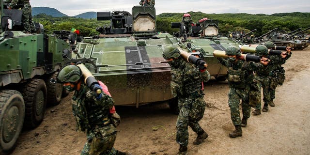 Soldiers carry ammunition to tanks during a two-day live-fire drill, in Pingtung county, Taiwan, on Sept. 7, 2022.