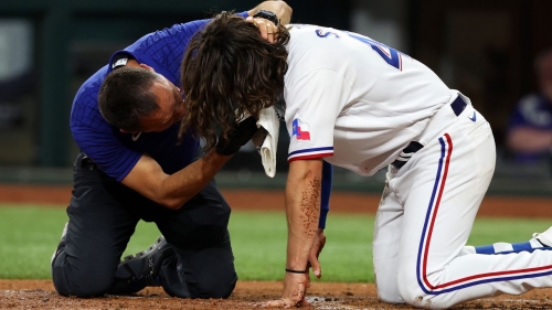 An athletic trainer for the Texas Rangers tends to Josh Smith after he was hit in the face by a pitch in the third inning against the Baltimore Orioles at Globe Life Field on Monday.