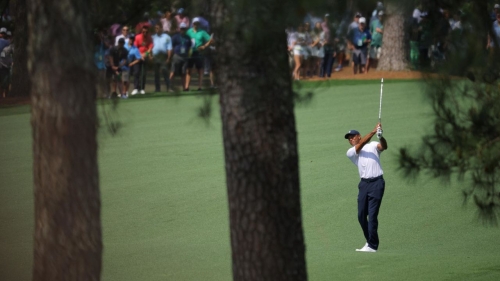 Woods hits his approach on the 7th hole.