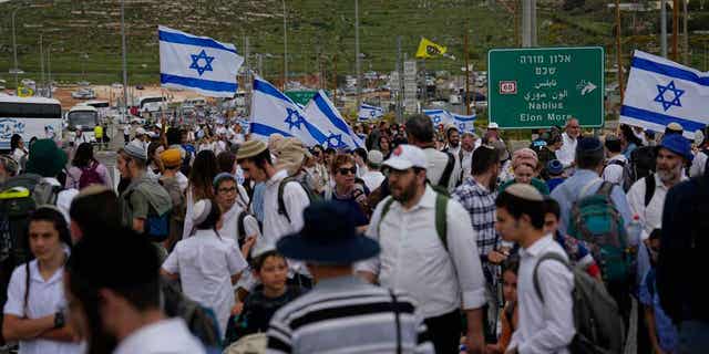 People march to outpost of Eviatar near Tapuah junction, West Bank, on April 10, 2023. The march to Eviatar, an unauthorized settlement outpost in the northern West Bank that was cleared by the Israeli government in 2021, was led by Jewish settlers.