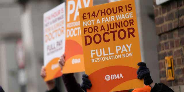 Junior doctors hold posters outside a hospital in London, on March 14, 2023. A four-day strike planned by doctors in England next week could lead to the postponement of a quarter-million medical appointments.