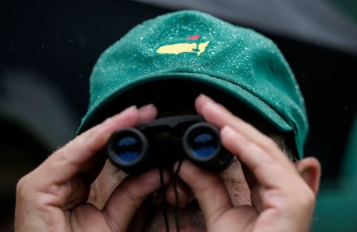 A spectator watches play on the 12th hole in the rain on Saturday.