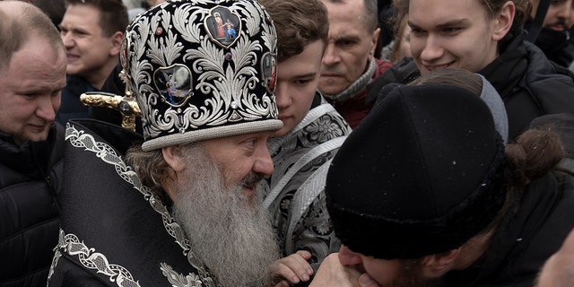A senior priest of the Ukrainian Orthodox Church walks by a crowd of people and blesses parishioners in the Kyiv Pechersk Lavra monastery complex in Kyiv, Ukraine, Wednesday, March 29, 2023. 