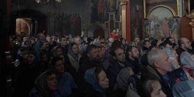 People gather to pray in the Kyiv Pechersk Lavra monastery complex in Kyiv, Ukraine, Wednesday, March 29, 2023.  