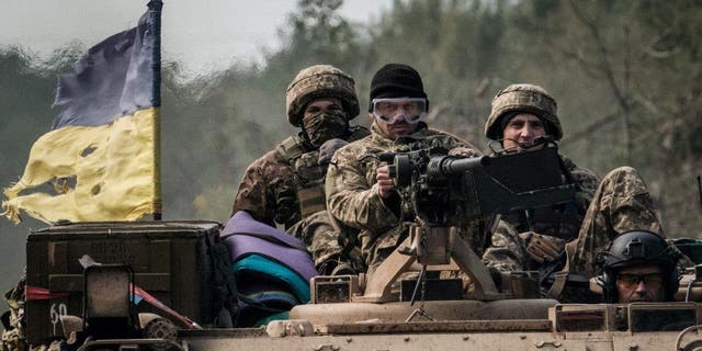 Ukrainian soldiers ride on an armored vehicle near the retaken town of Lyman in Donetsk region Oct. 6, 2022, amid the Russian invasion of Ukraine.