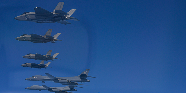In this photo provided by South Korea Defense Ministry, U.S. Air Force B-1B bombers (bottom left) fly in formation with South Korea's Air Force F-35A fighter jets and U.S. Air Force F-16 fighter jets (bottom right) over the South Korea Peninsula during a joint air drill in South Korea.
