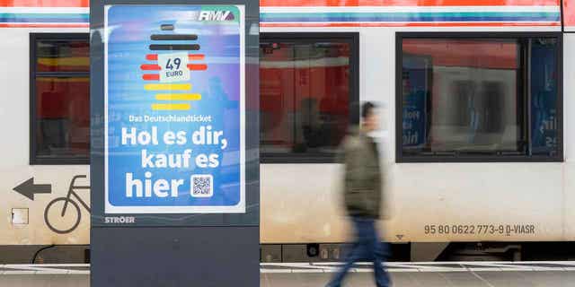 A man passes by an advertising for the Deutschlandticket
