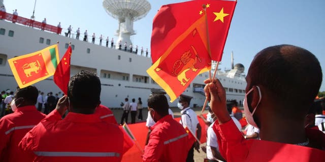 People wave Chinese flags in Sri Lanka