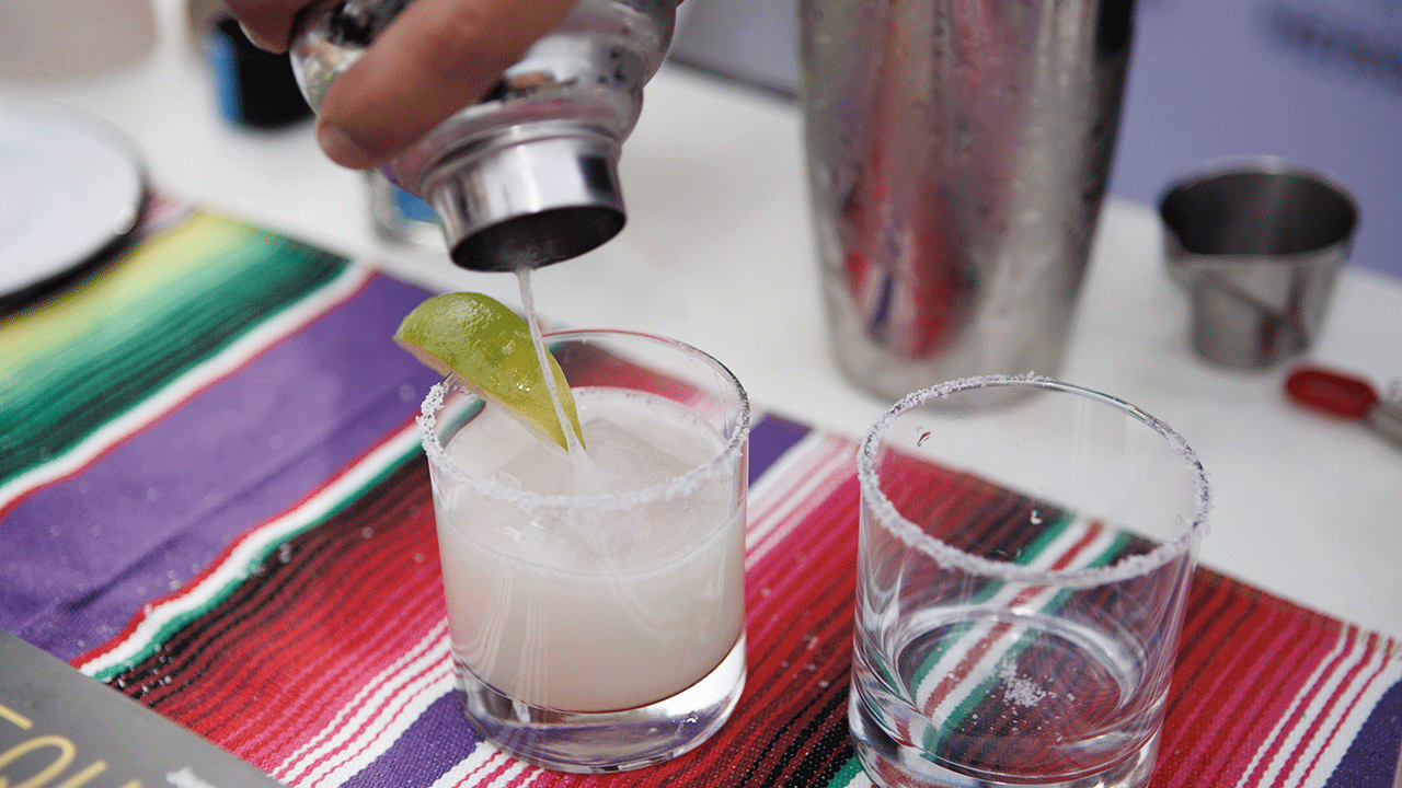 Someone pouring a margarita