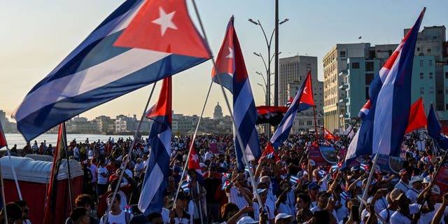 Demonstrators wave Cuban flags