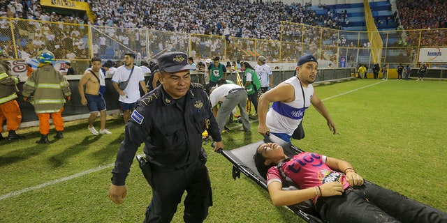 aid workers carrying woman on stretcher