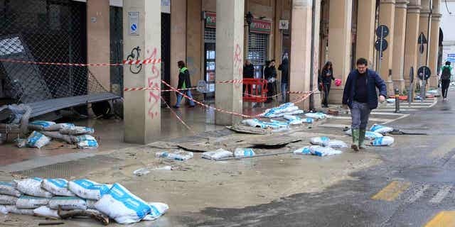 Mud and sand bags lie on the side of a street