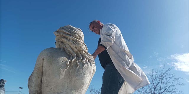 sculptor with his mermaid statue