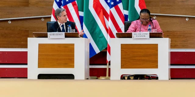 Blinken and Pandor at summit, US, South Africa flags behind them