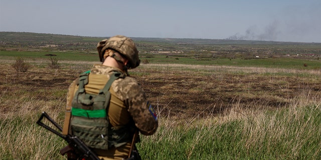 A Ukrainian serviceman looks as smoke rises after a Russian troops shelling, as Russia's attack on Ukraine continues, in Luhansk Region, Ukraine April 26, 2022. REUTERS/Serhii Nuzhnenko