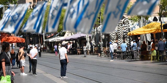 Streets in Israel lined with Israeli flags and people in silence