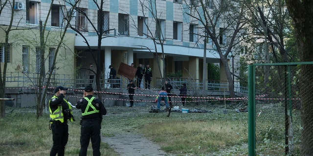 Officers review damaged building in Kyiv