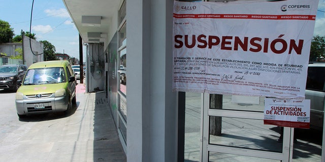 A sign outside a health clinic in Matamoros, Mexico, reads "suspended"