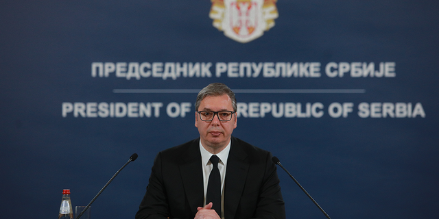President of Serbia speaking in front of microphones to his nation