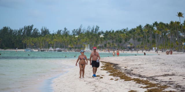 Tourists walk on beach