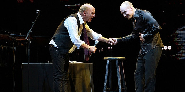 Art Garfunkel and his son smiling on stage and performing together