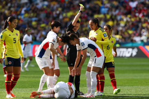 Colombia midfielder Manuela Vanegas receives a yellow card from referee Rebecca Welch.