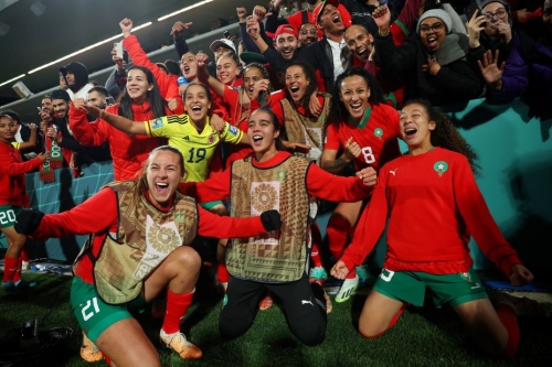 Morocco's players celebrate advancing to last 16 after beating Colombia.