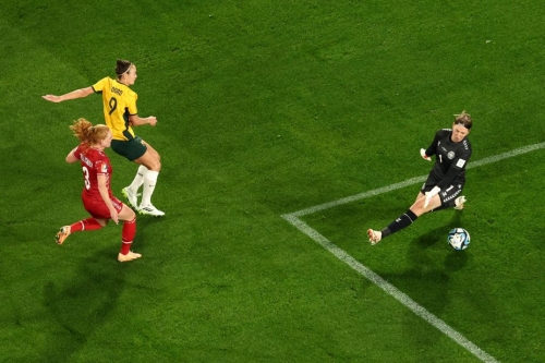 Australia's forward Caitlin Foord scores a goal past Denmark's goalkeeper Lene Christensen.