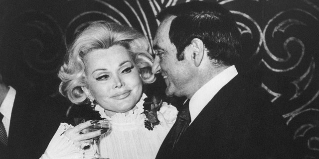 Zsa Zsa Gabor and Jack Ryan toast together.