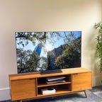 LG C OLED TV on a wood cabinet.