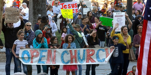 Protesters hold an "open church" sign in support of Calvary Chapel San Jose