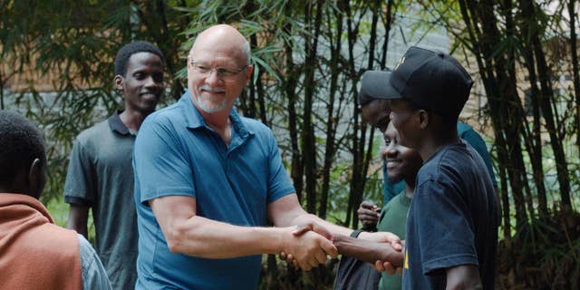 missionary shakes hands another man