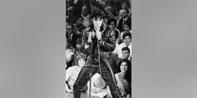 Elvis Presley singing in a leather suit
