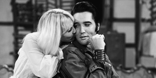 A close-up of Susan Henning kissing Elvis Presleys cheek