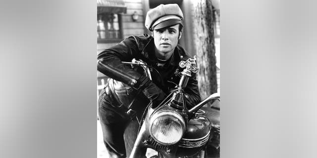 Marlon Brando wearing a leather jacket sitting on top of a motorcycle