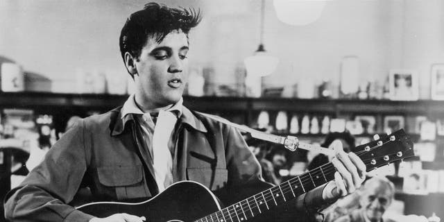 Elvis Presley strums guitar on set of movie