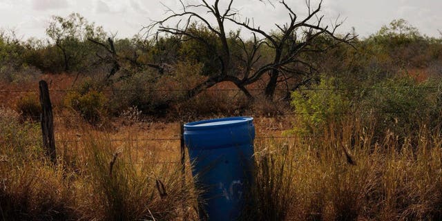 border Texas Mexico water barrel