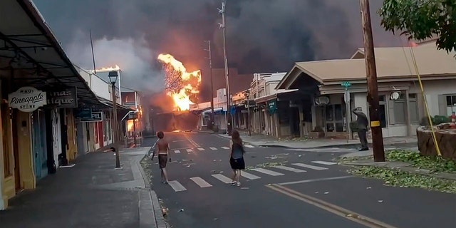 people in street as fire rages