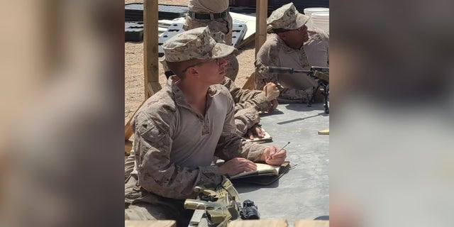 Merola taking notes in Marine fatigues
