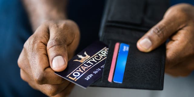 Photo of a man pulling out his loyalty card form his wallet.