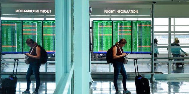 Traveler checks phone at Reagan National Airport in the Washington area