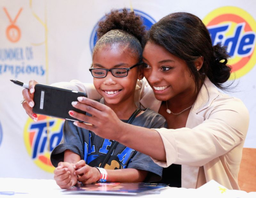 Biles takes a photo with a young fan in Houston in September 2016.