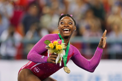 Biles dodges a bee flying near her during the medal ceremony at the 2014 World Championships. She successfully defended her title in the individual all-around.