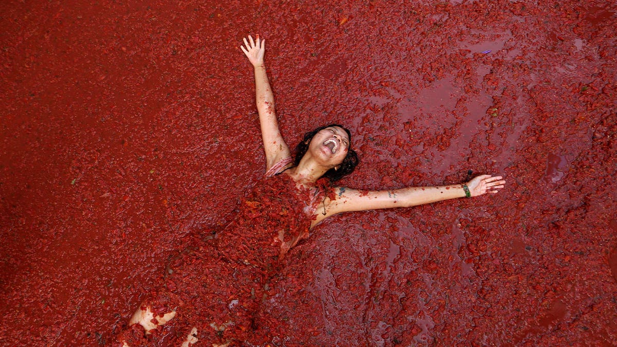 women in red tomato pulp bath