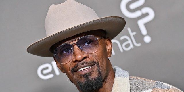 Jamie Foxx wears tan hat and coat on red carpet