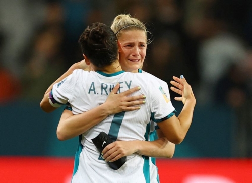 Ali Riley and Katie Bowen hug after New Zealand was knocked out of the tournament on July 30. The co-hosts drew Switzerland 0-0, but they will miss the knockout stage because of goal differential.
