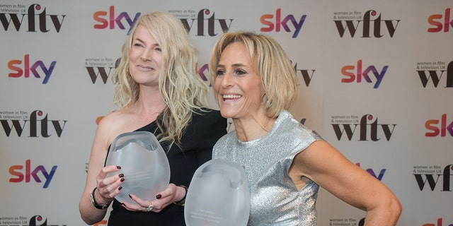 Sam McAllister in a one sleeved black dress and Emily Maitlis wearing a silver sleeveless dress as they hold awards
